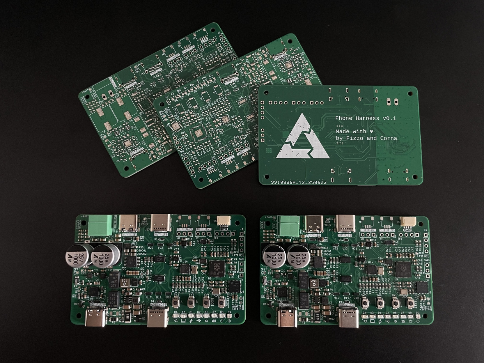 several populated PCBs next to each other on a desk. The back shows the postmarketOS logo and some text "phone harness v0.1 made with love by fizzo and ncorna" several populated PCBs next to each other on a desk. The back shows the postmarketOS logo and some text "phone harness v0.1 made with love by fizzo and ncorna"