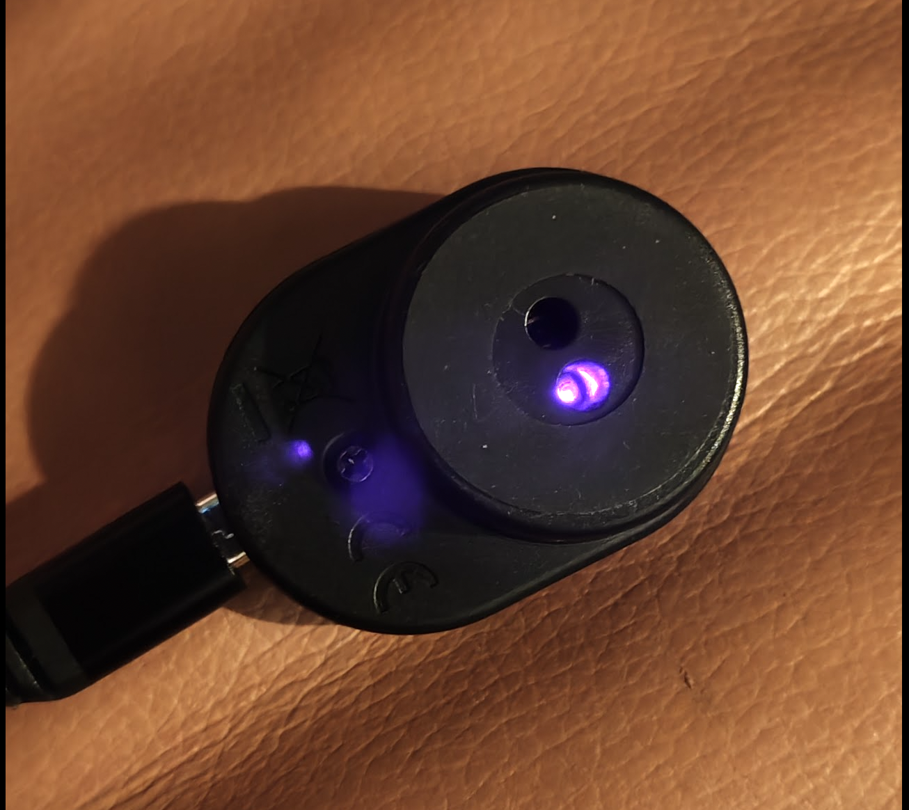 Stromleser tasmota mit auf der Handykamera sichtbarer IR Diode. Der untere Teil, in den das Kabel geht, kollidiert mit meinem Stromzähler.